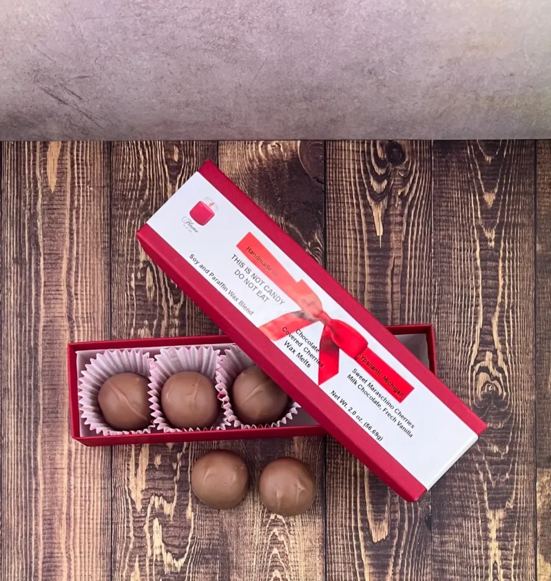 A box of chocolate truffles on top of a wooden table.