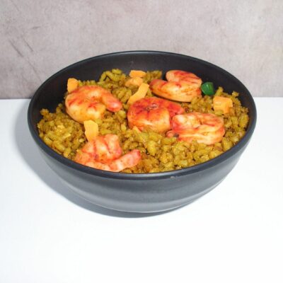 A bowl of yellow rice with four shrimp.